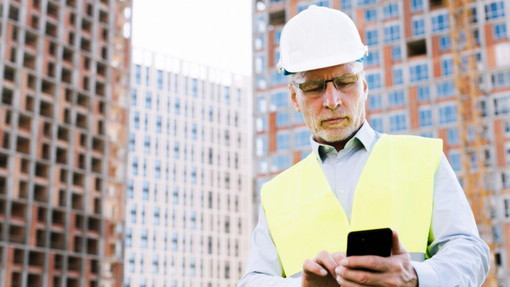 Construction worker looking at his phone