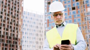 Construction worker looking at his phone